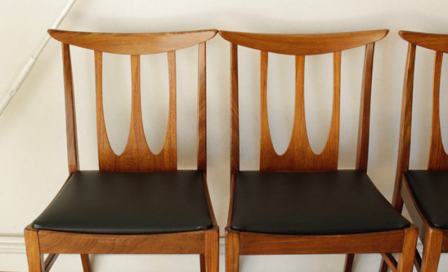 Set of four vintage G-Plan Brasilia dining chairs in teak with black leather seats, British mid-century design featuring.