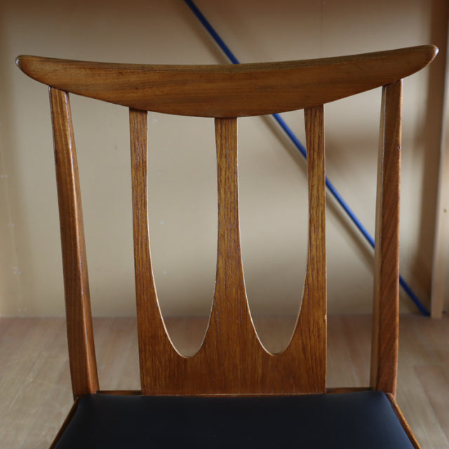 Vintage G-Plan mid-century teak dining chair with curved backrest, tapered legs, and black seat cushion.
