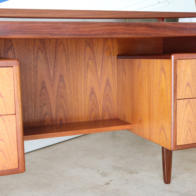 Vintage G-plan mid-century teak desk with smooth wood grain, tapered legs, and symmetrical drawers, British design with.