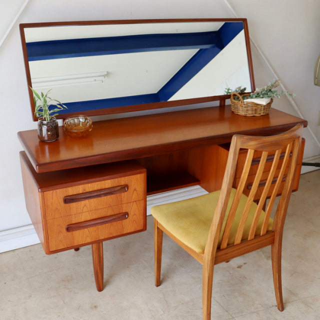 Vintage G-Plan mid-century teak desk with rich wood grain, tapered legs, and matching chair with cushioned seat.