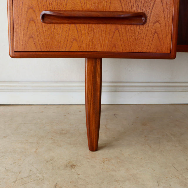 Mid-century British G-Plan vintage teak desk leg and drawer with rich wood grain and smooth rounded handle.