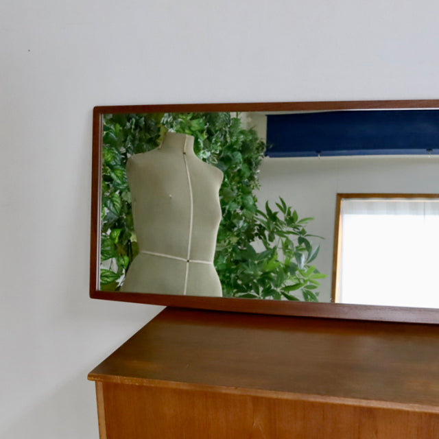 Mid-century British vintage teak desk with smooth wood grain and sleek angled edges, no mirror attached.