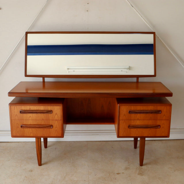 Vintage British G-Plan teak mid-century desk with wood grain, tapered legs, rectangular mirror with blue and cream stripes,.