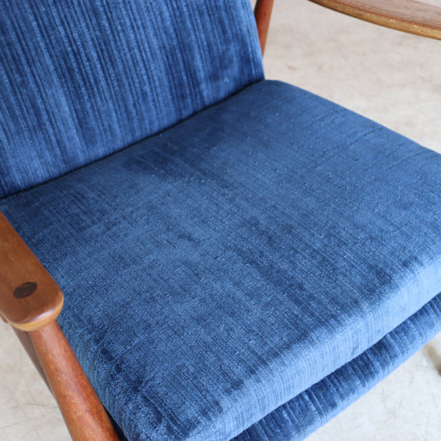 Mid-century vintage Danish armchair with rich teak frame and deep blue textured fabric upholstery.