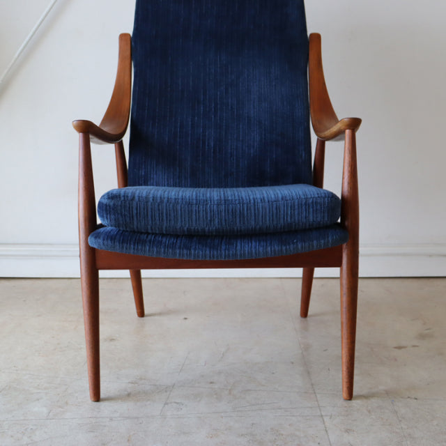 Vintage mid-century Danish armchair with highback in rich teak frame and deep blue corduroy upholstery, showcasing sleek.
