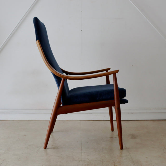 Mid-century vintage Danish armchair with high back, teak wood frame, and deep navy upholstered seat and backrest.