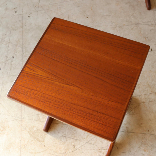 Square mid-century British G-Plan teak nest table with smooth wood grain and tapered legs on polished floor.