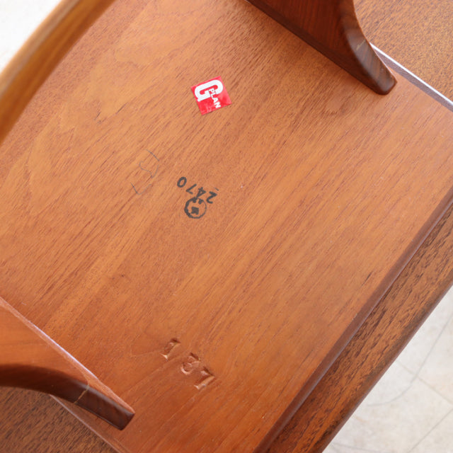 Underside of vintage British G-Plan teak nest table showing natural wood grain, stamped markings, and tapered legs in.