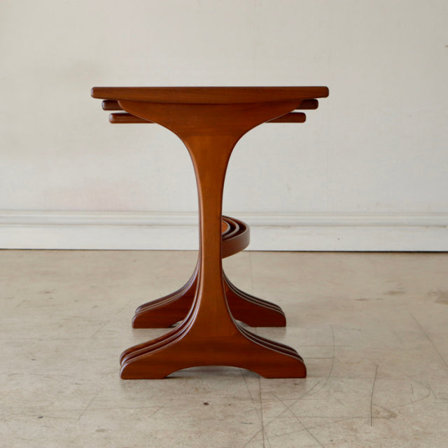 Vintage British mid-century teak G-Plan nest table with sculpted pedestal base and smooth wood grain finish.