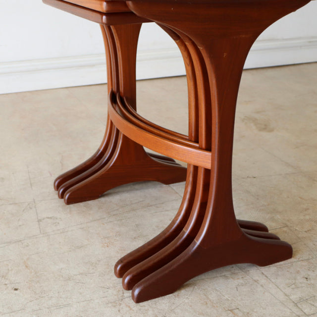 Mid-century British teak G-Plan nest table legs showcasing rich wood grain and curved, sculpted form.