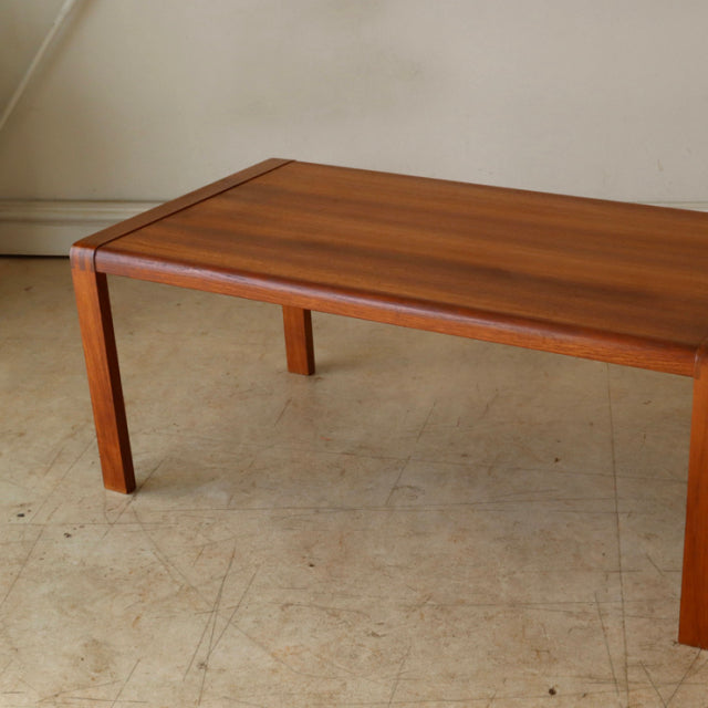 Vintage mid-century British teak coffee table with clean rectangular top, straight legs, and smooth wood grain finish.