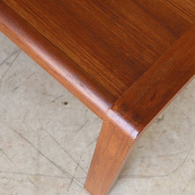 Mid-century British vintage teak coffee table corner with smooth wood grain and rounded edge legs from Denmark style.
