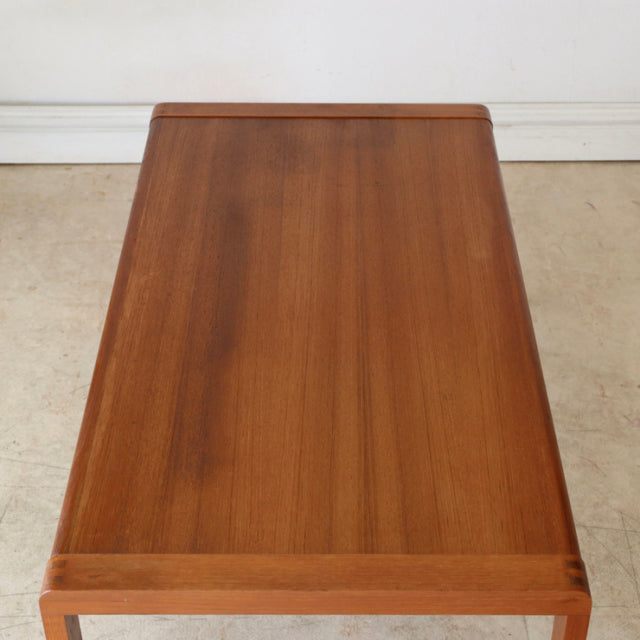 Mid-century British vintage teak coffee table with sleek rectangular top and tapered legs showcasing rich wood grain from.