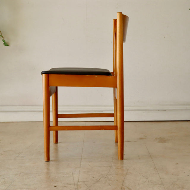 Mid-century British vintage teak dining chair with sleek wood grain and black upholstered seat, showcasing clean lines and.