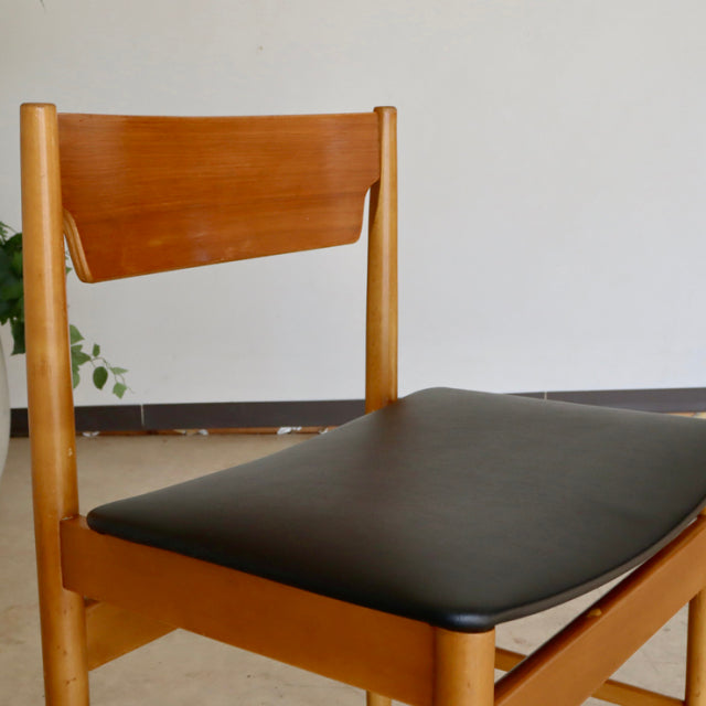 Mid-century vintage British teak dining chair with smooth wood grain and black upholstered seat.