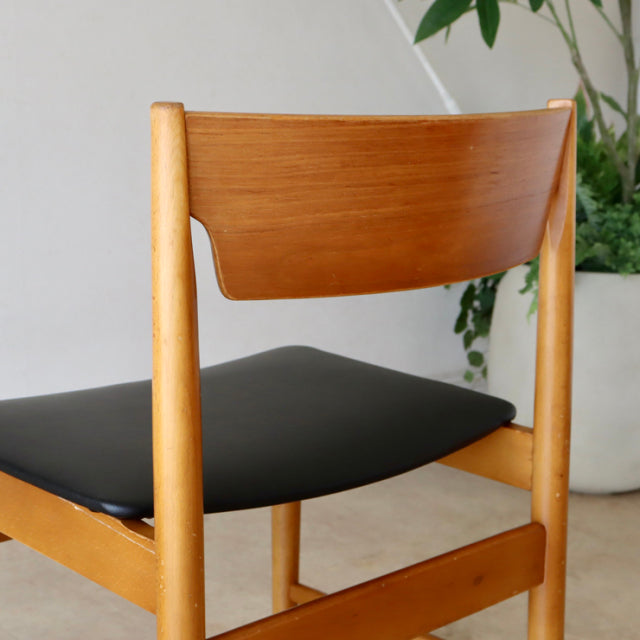 Mid-century British vintage teak dining chair with smooth wood grain and black upholstered seat.
