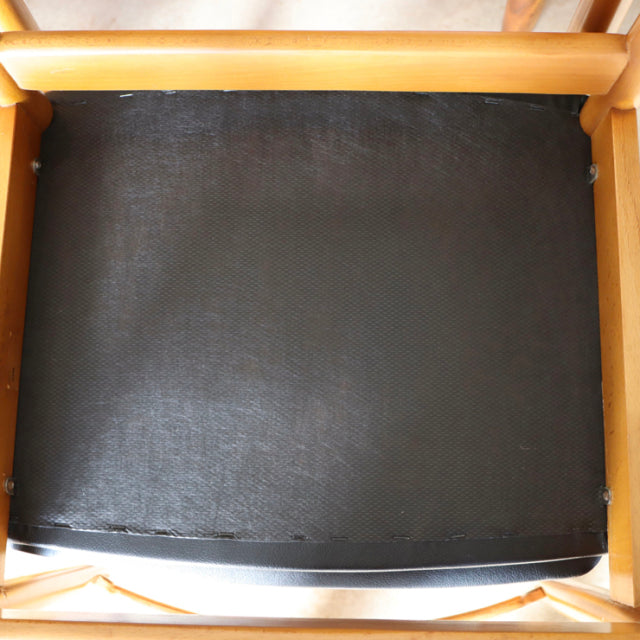 Vintage teak dining chair seat base showing black fabric upholstery with visible texture and wooden frame edges, mid-century .