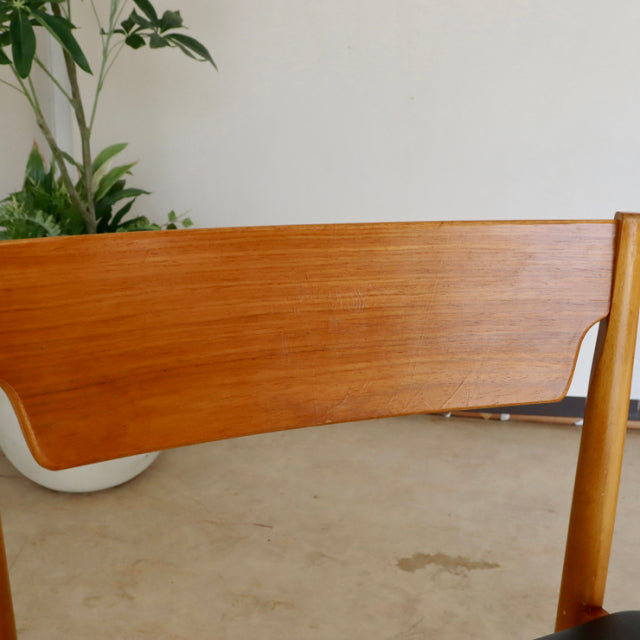 Mid-century British vintage teak dining chair backrest with smooth grain and sleek wooden frame.