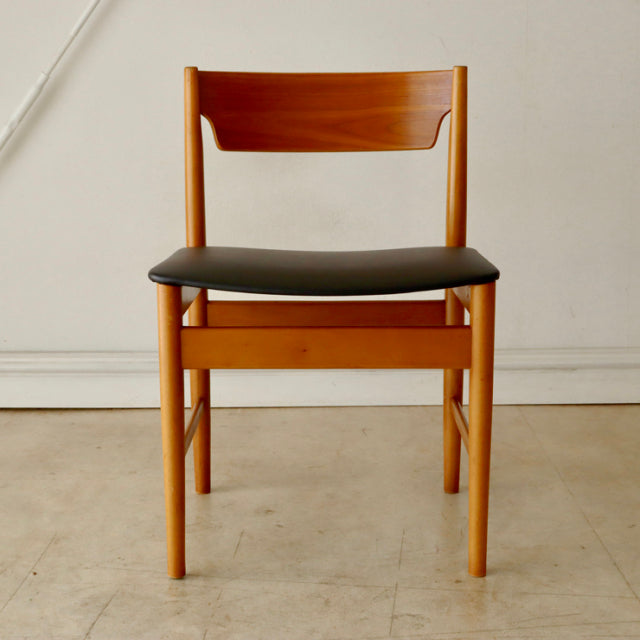 Mid-century British vintage teak dining chair with clean wood grain and black cushioned seat.