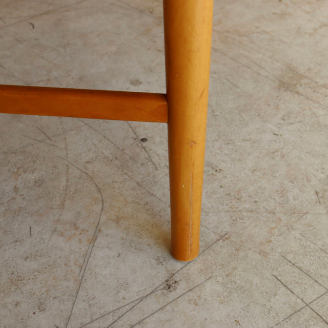 Mid-century vintage teak dining chair leg with smooth cylindrical form and warm wood grain from British-Denmark design.