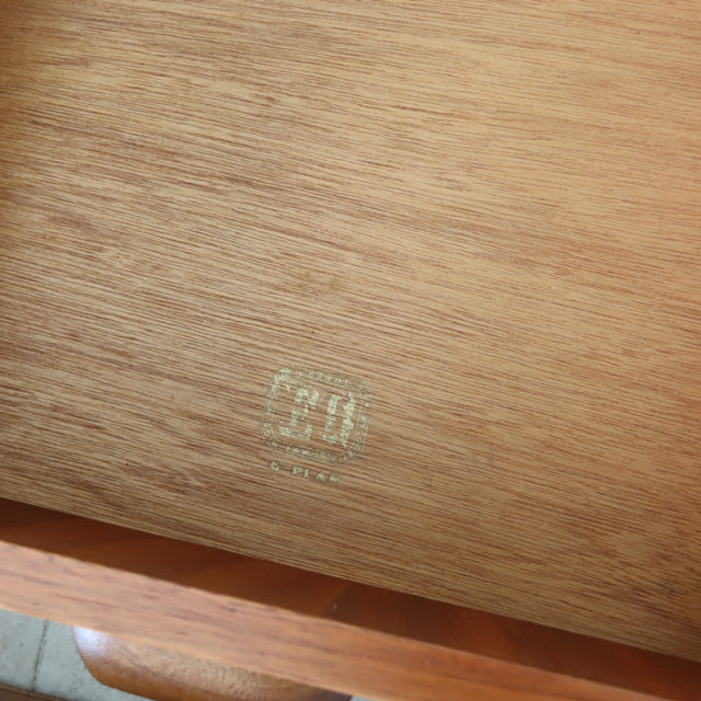 Close-up of vintage teak wood grain and G-PLAN British mid-century furniture brand stamp on sideboard interior panel.