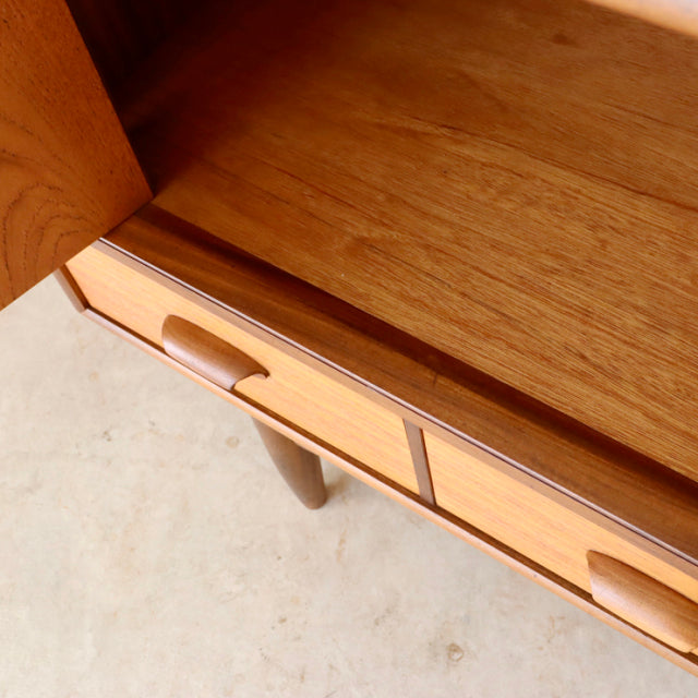 Vintage teak G-Plan sideboard with smooth wood grain, recessed handles, and tapered mid-century British legs from Denmark.