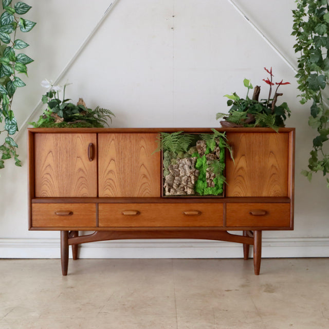 Mid-century British vintage teak G-PLAN sideboard with clean wood grain, four doors, three drawers, tapered legs, and.