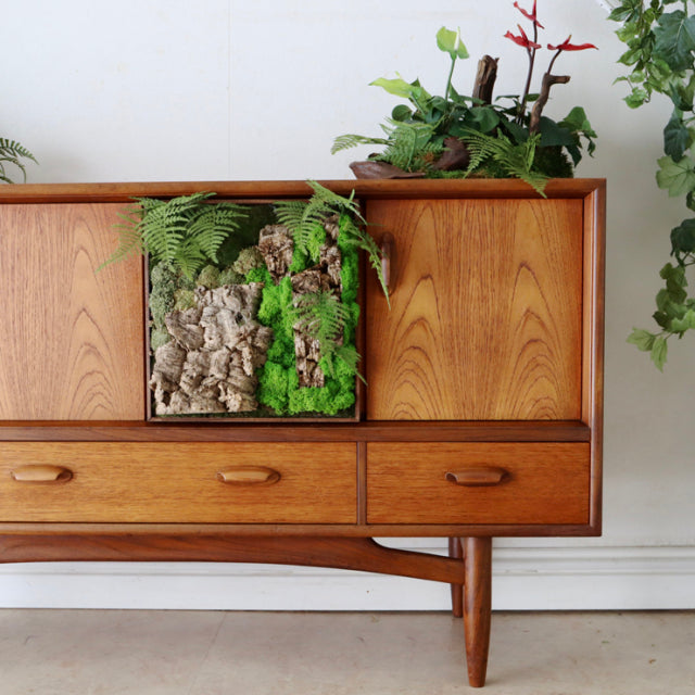 Mid-century British G-PLAN sideboard in teak with smooth wood grain, three drawers, two cabinets, and tapered legs.