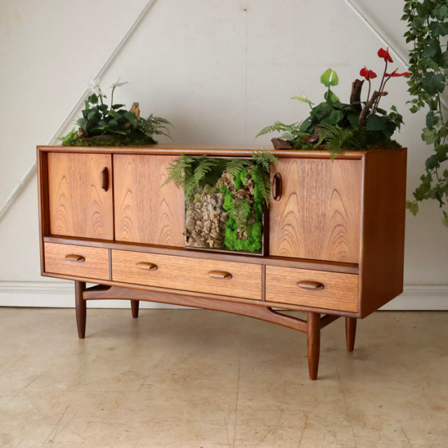 Vintage British mid-century teak G-PLAN sideboard with rich wood grain, three sliding doors, and three lower drawers on.