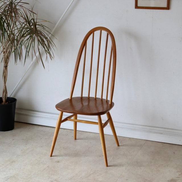 Vintage mid-century British Ercol Quaker dining chair in natural teak with curved spindle backrest and tapered legs,.