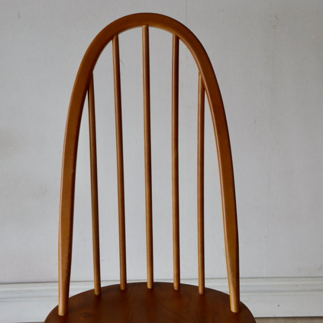 Vintage Arcol Quaker chair in natural teak with curved high back and slender vertical spindles, mid-century British design.