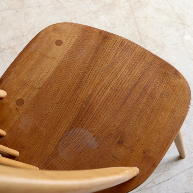 Vintage Ercol Quaker chair seat showcasing warm teak wood grain and smooth curved edges in mid-century British design.