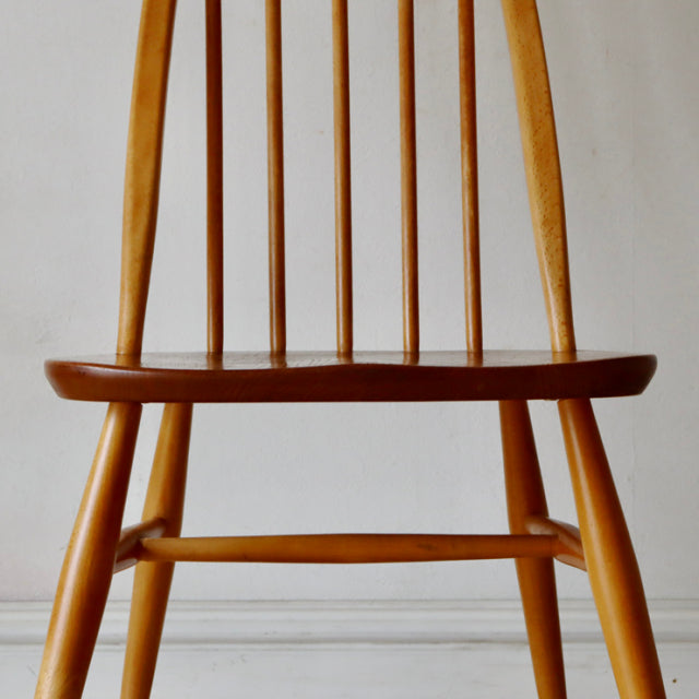 Vintage British Ercol Quaker dining chair in natural teak with mid-century spindle back and tapered legs.