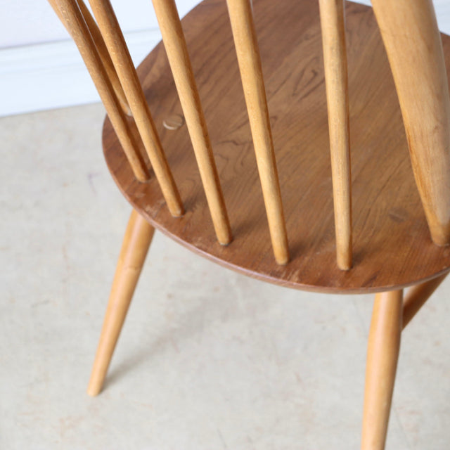 Vintage British mid-century Ercol Quaker dining chair in natural teak with spindle back and tapered legs.