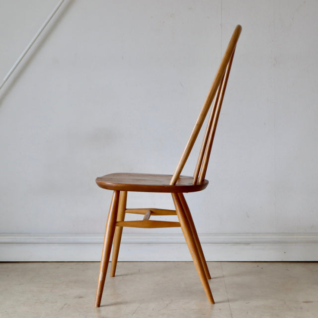 Vintage British mid-century Ercol Quaker chair in natural teak with slender spindle back and tapered legs.