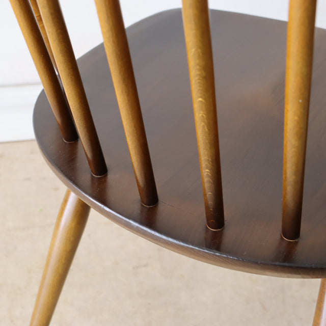 Vintage British Ercol Quaker chair in rich teak with slender spindle backrest and angled teak legs, mid-century Denmark.