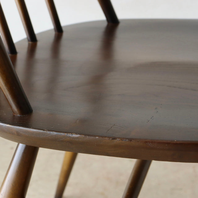 Close-up of vintage British Ercol Quaker chair seat and legs in rich teak with visible wood grain and smooth mid-century.