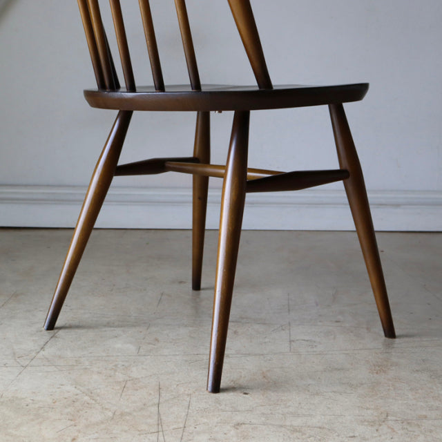 Vintage British mid-century Ercol Quaker chair in rich teak with elegant tapered legs and visible wood grain.