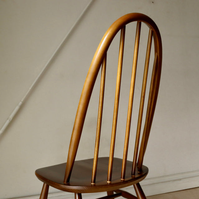 Vintage British mid-century ERCOL Quaker chair in polished teak with spindle backrest and gently curved legs.