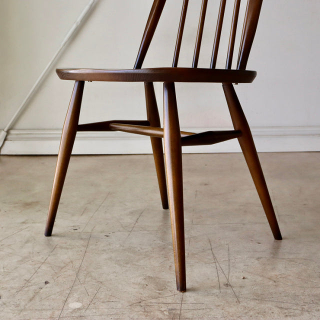 British mid-century ERCOL Quaker dining chair in teak with tapered legs and visible wood grain.