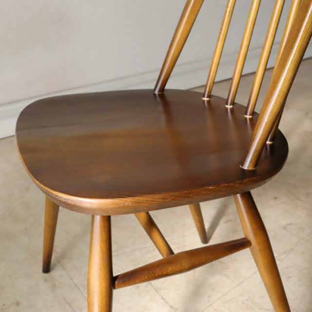 Vintage mid-century British ERCOL Quaker chair in polished teak with elegant spindle back and tapered legs.