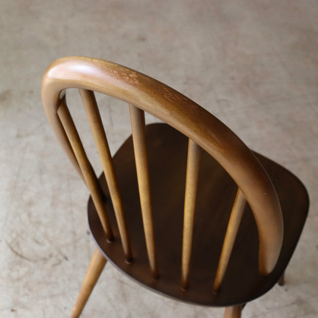 Vintage British mid-century Ercol Quaker chair in teak with curved spindle back and tapered legs.