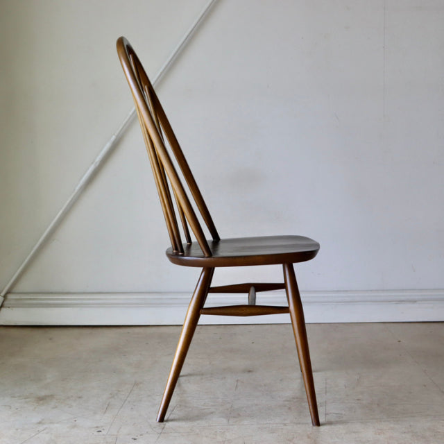 Vintage British Arcol mid-century teak dining chair with curved spindle back and tapered legs.