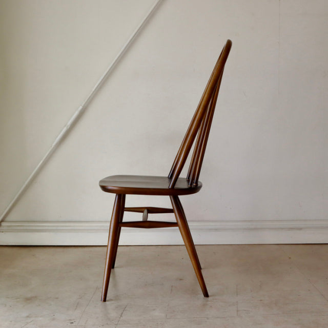 Vintage British Ercol Quaker chair in warm teak with slender spindled back and tapered legs, mid-century design.