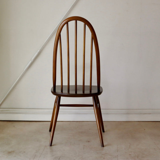 Vintage British Ercol Quaker dining chair in warm teak with curved spindle back and tapered legs, mid-century design from.