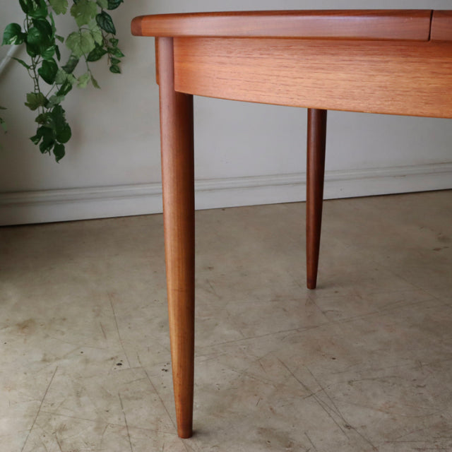 Vintage G-Plan teak dining table leg and rounded edge showing mid-century British design and Danish wood grain finish.