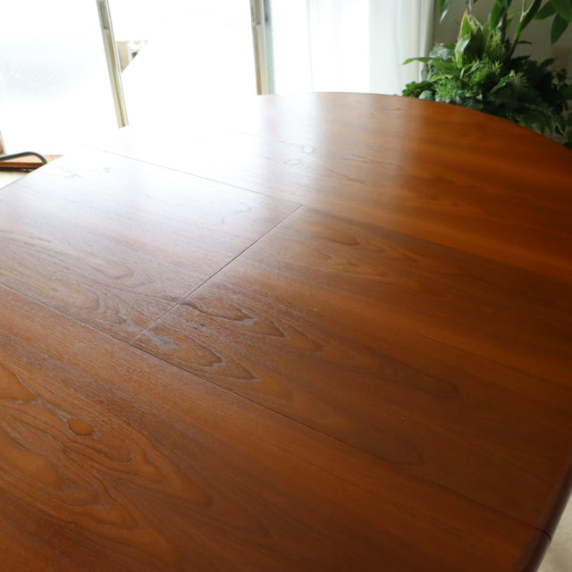 Vintage G-Plan teak dining table with smooth rounded edges, mid-century British design featuring warm wood grain and elegant .