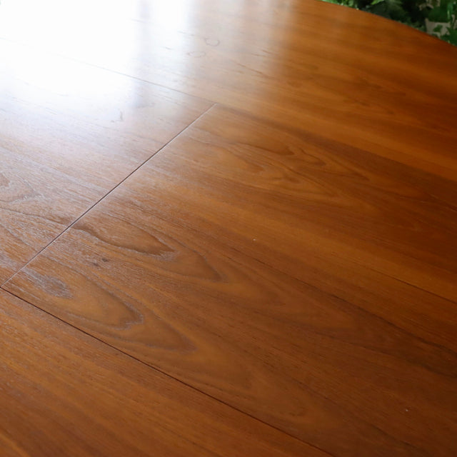 Mid-century vintage British G-Plan dining table in polished teak with smooth oval top and subtle wood grain patterns.