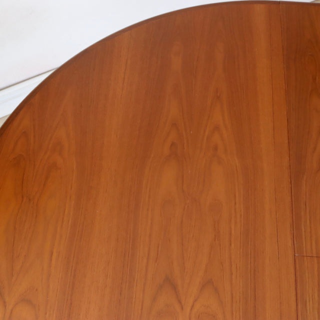 Vintage teak G-Plan mid-century dining table with smooth oval top and visible wood grain, British design inspired by Denmark .
