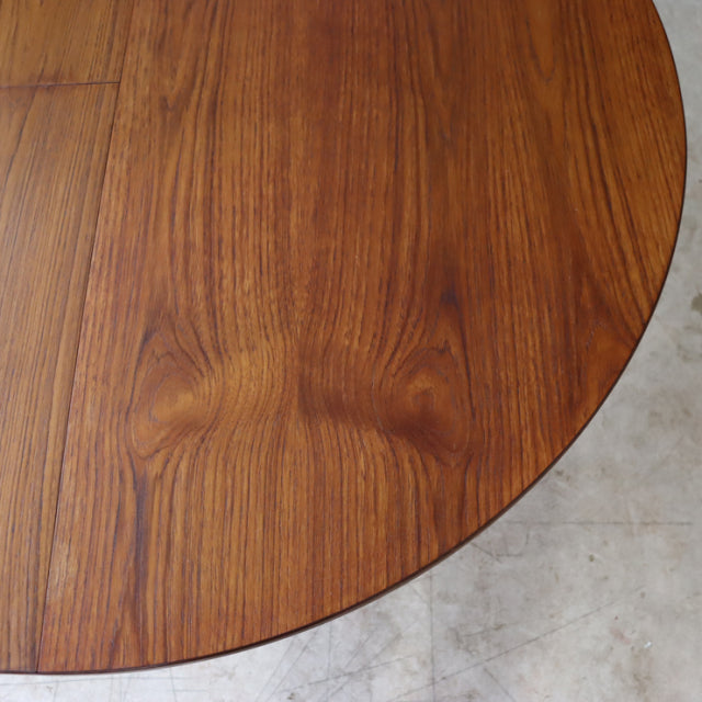 Round vintage teak dining table top with rich wood grain and warm mid-century British design.